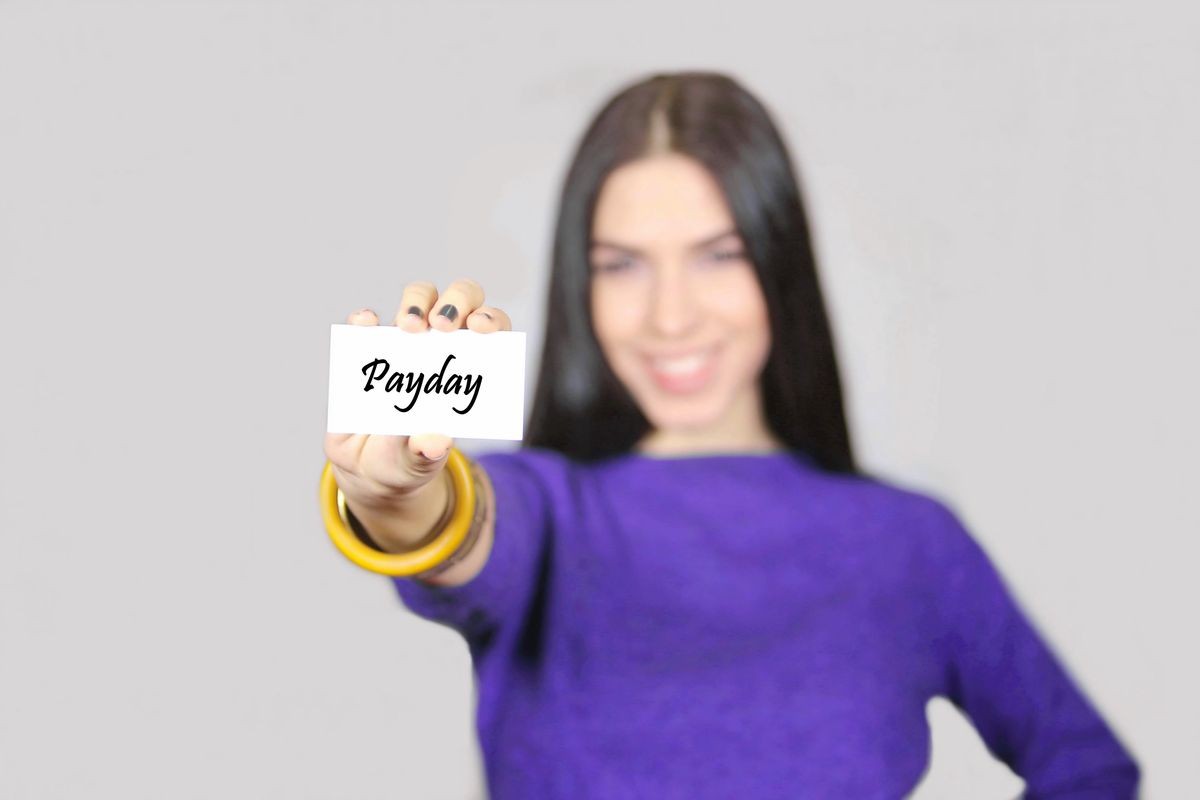 Female holding business card with message Payday